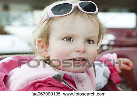 Stock Photography - Toddler girl with sunglasses on her head, portrait. Fotosearch