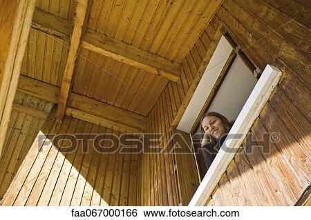 Woman looking out window, looking down at camera View Large Photo Image Stock Photograph - Woman looking out window, looking down at camera. Fotosearch
