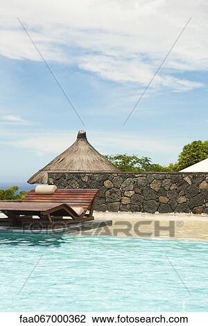 Wooden lounge chair in pool at resort View Large Photo Image Stock Image - Wooden lounge chair in pool at resort. Fotosearch
