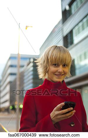 Stock Photo - Young woman using cell phone, portrait. Fotosearch