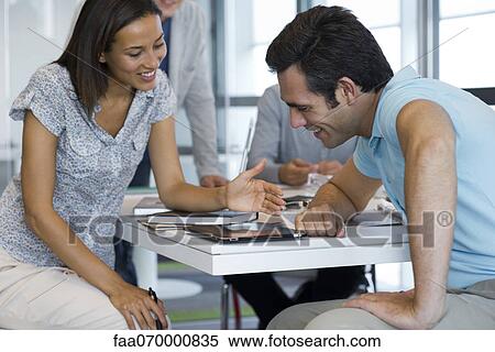 Stock Photography - Associates working together with digital tablet. Fotosearch