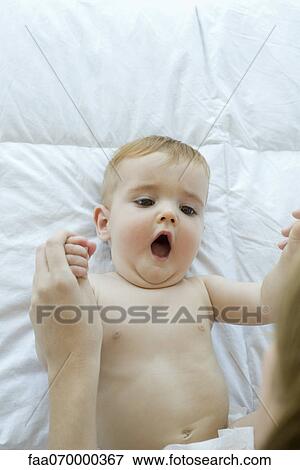 Baby lying on back, playing with mother View Large Photo Image Stock Photo - Baby lying on back, playing with mother. Fotosearch