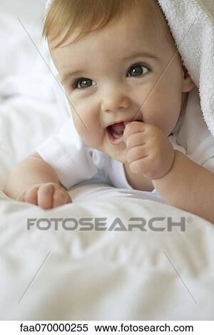 Baby lying on blanket, sticking thumb in mouth, portrait View Large Photo Image Stock Photography - Baby lying on blanket, sticking thumb in mouth, portrait. Fotosearch