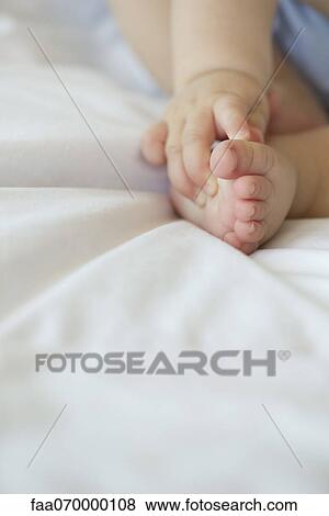 Baby touching its foot, cropped View Large Photo Image Stock Photo - Baby touching its foot, cropped. Fotosearch