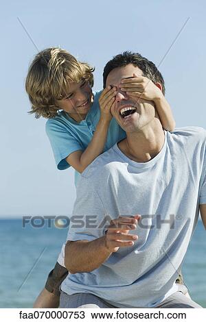 Boy covering father's eyes with hands View Large Photo Image Stock Image - Boy covering father's eyes with hands. Fotosearch