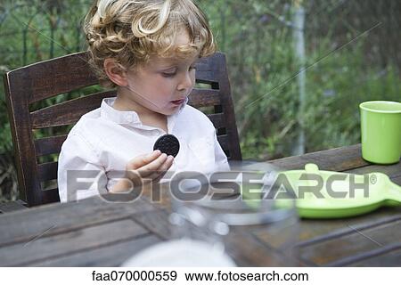 Boy eating cookie outdoors View Large Photo Image Stock Photo - Boy eating cookie outdoors. Fotosearch