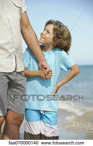 Boy holding father's hand at the beach View Large Photo Image Stock Image - Boy holding father's hand at the beach. Fotosearch