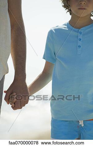 Boy holding father's hand outdoors, cropped View Large Photo Image Stock Photo - Boy holding father's hand outdoors, cropped. Fotosearch