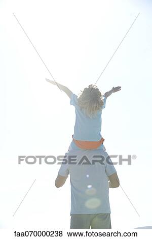 Boy riding on father's shoulders, rear view View Large Photo Image Stock Photo - Boy riding on father's shoulders, rear view. Fotosearch