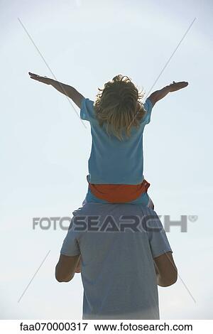 Boy riding on father's shoulders, rear view View Large Photo Image Stock Photo - Boy riding on father's shoulders, rear view. Fotosearch