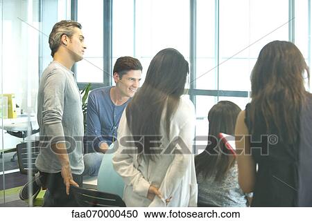 Stock Image - Business associates in casual meeting. Fotosearch