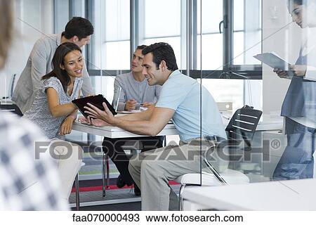 Business associates working together with digital tablet View Large Photo Image Stock Image - Business associates working together with digital tablet. Fotosearch