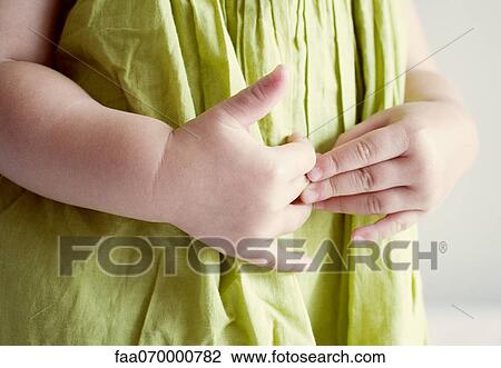 Stock Image - Child putting hands on stomach. Fotosearch