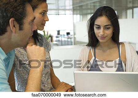 Stock Photo - Colleagues collaborating in office. Fotosearch