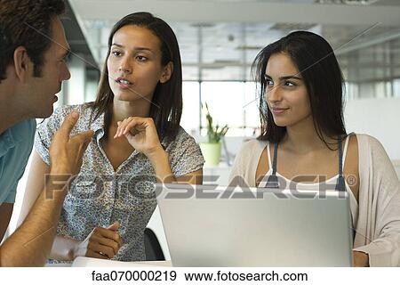 Colleagues collaborating in office View Large Photo Image Stock Photo - Colleagues collaborating in office. Fotosearch