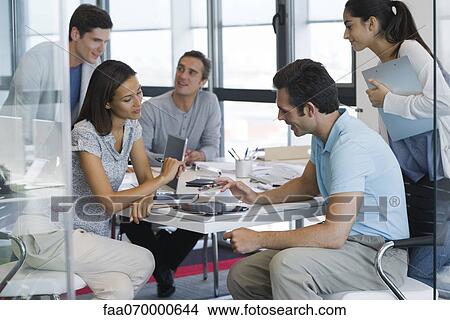 Picture - Colleagues working with digital tablet in office. Fotosearch