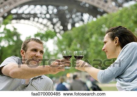 Couple clinking wine glasses outdoors View Large Photo Image Stock Photography - Couple clinking wine glasses outdoors. Fotosearch