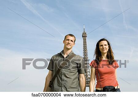 Picture - Couple in front of Eiffel Tower, Paris, France. Fotosearch