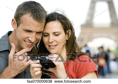 Stock Photo - Couple looking at pictures on digital camera. Fotosearch
