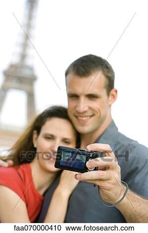 Couple photographing selves in front of Eiffel Tower, Paris, France View Large Photo Image Stock Image - Couple photographing selves in front of Eiffel Tower, Paris, France. Fotosearch