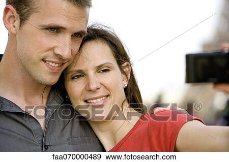 Stock Photo - Couple photographing themselves outdoors. Fotosearch