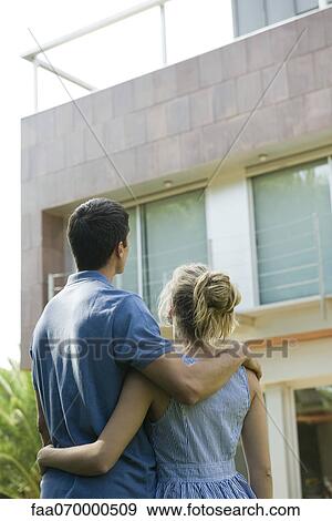 Couple standing together, looking at home, rear view View Large Photo Image Stock Photo - Couple standing together, looking at home, rear view. Fotosearch