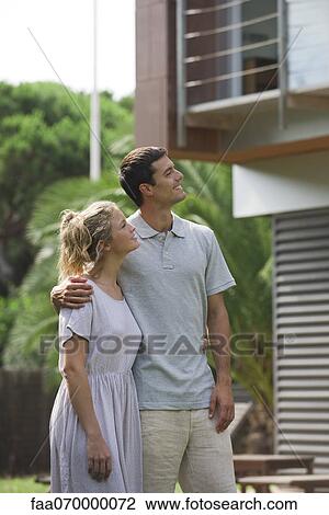 Stock Image - Couple standing together outdoors. Fotosearch