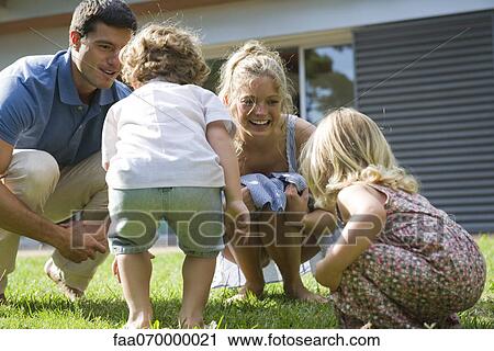 Stock Image - Family playing together outdoors. Fotosearch