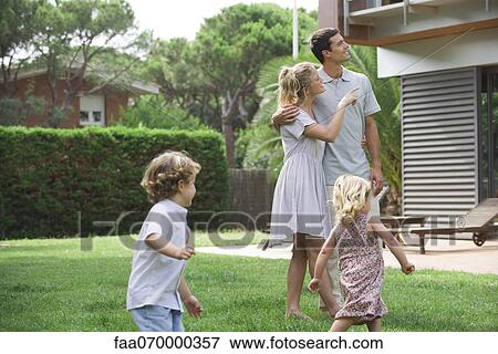 Family relaxing together in backyard View Large Photo Image Stock Photo - Family relaxing together in backyard. Fotosearch