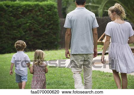 Stock Image - Family walking together outdoors, rear view. Fotosearch