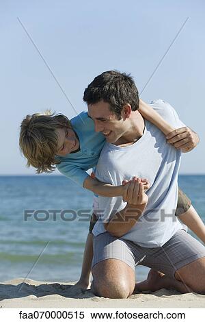 Stock Photography - Father and son having fun together at the beach. Fotosearch