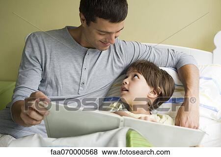 Father and son reading book together View Large Photo Image Stock Photo - Father and son reading book together. Fotosearch