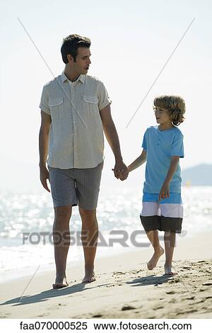 Father and son walking hand in hand on beach View Large Photo Image Stock Photography - Father and son walking hand in hand on beach. Fotosearch