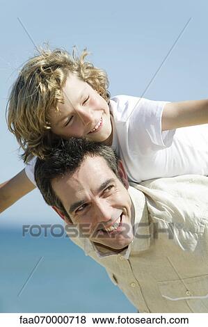 Stock Photo - Father giving son piggback ride outdoors. Fotosearch