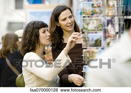 Female tourists looking at postcards View Large Photo Image Stock Photo - Female tourists looking at postcards. Fotosearch
