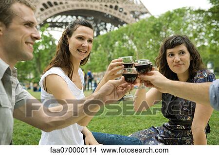 Picture - Friends clinking wine glasses outdoors. Fotosearch