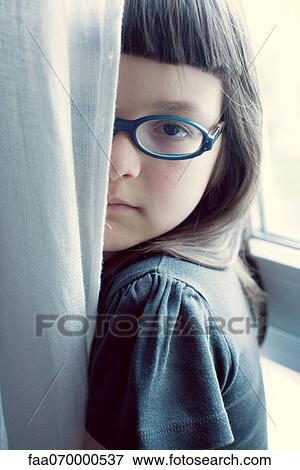 Stock Photo - Girl hiding behind curtain. Fotosearch