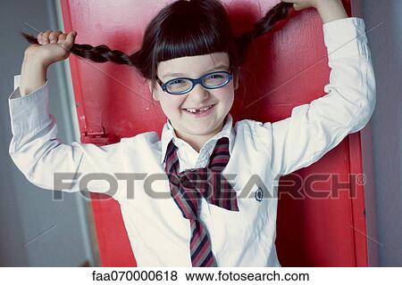 Stock Photo - Girl holding up pigtails, portrait. Fotosearch