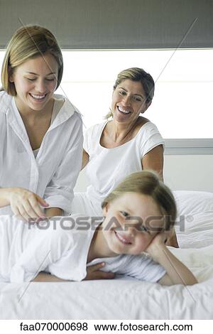 Girl relaxing on bed with her mother and grandmother View Large Photo Image Stock Photo - Girl relaxing on bed with her mother and grandmother. Fotosearch