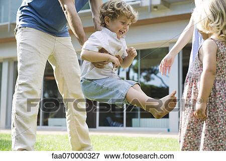 Stock Photo - Little boy playing with his family outdoors. Fotosearch