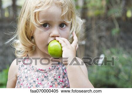 Little girl biting into lime View Large Photo Image Stock Photography - Little girl biting into lime. Fotosearch