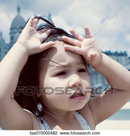 Stock Image - Little girl feeling hot under sun. Fotosearch