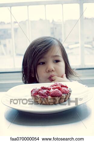 Little girl licking finger, raspberry tart in front View Large Photo Image Picture - Little girl licking finger, raspberry tart in front. Fotosearch