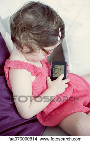 Picture - Little girl looking at picture on digital camera. Fotosearch