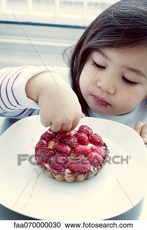 Little girl picking at raspberry tart View Large Photo Image Stock Image - Little girl picking at raspberry tart. Fotosearch