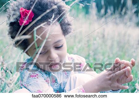 Stock Photograph - Little girl playing outdoors. Fotosearch