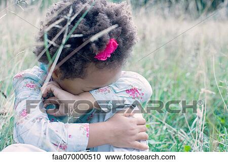 Stock Image - Little girl resting head on arm. Fotosearch