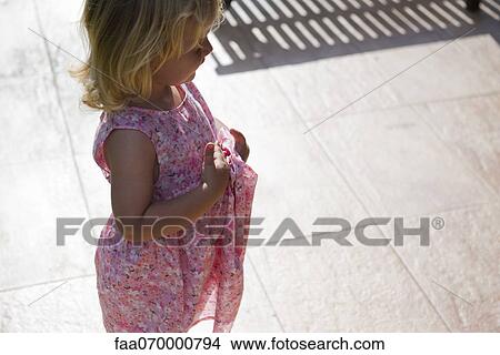 Little girl standing outdoors, looking away in thought View Large Photo Image Picture - Little girl standing outdoors, looking away in thought. Fotosearch