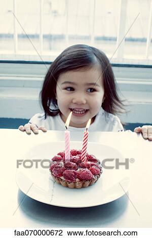 Stock Image - Little girl with birthday cake. Fotosearch