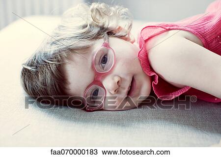 Little girl with glasses lying on side View Large Photo Image Stock Image - Little girl with glasses lying on side. Fotosearch